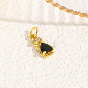 Detailed close-up of a 18k gold-plated turtle pendant with sparkling black and clear crystals