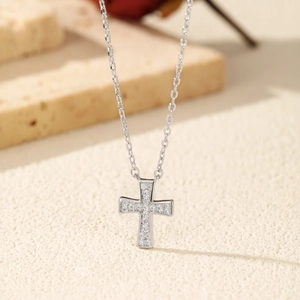 Polished S925 sterling silver cross necklace with D color moissanite on beige texture