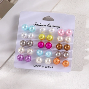 Detail view of 12 pairs colorful round faux pearl earrings set on display card