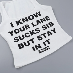 Detailed view of white ribbed crop top featuring black typography slogan on the front