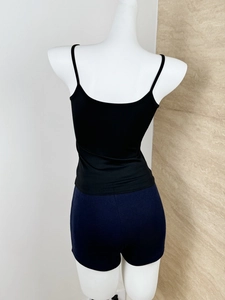 Rear view of a black slim-fit tank top with thin straps and navy blue shorts