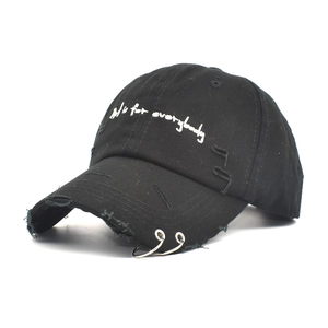 Black canvas baseball cap with metal rings and distressed hole details and embroidery