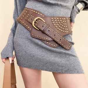 Close-up of vintage wide leather waist belt with bronze studs and rustic metal buckle