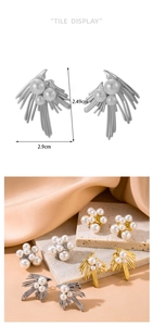 Detailed view of pearl leaf earrings with size markings 2.49cm by 2.9cm on silk