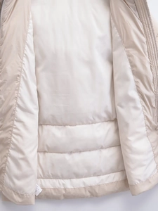 Detail of the horizontal quilted lining and wash label on this beige winter jacket
