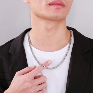 Close-up of a silver cuban link chain necklace worn by a man for a hip hop style look