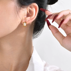 Detailed close-up of a gold-plated stainless steel hoop earring with a clear zircon stone