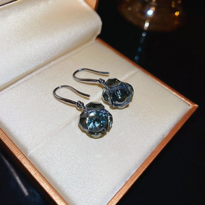 Gros plan détaillé de boucles d'oreilles pendantes en cristal bleu foncé en coffret