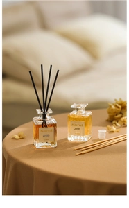 Detailed view of square glass aroma diffuser bottles with amber liquid and fiber reeds