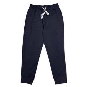 Detail of dark drawstring sweatpants featuring textured diamond jacquard and ribbed cuffs