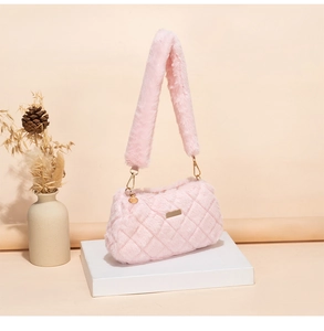 Detail of pink plush shoulder bag featuring quilted texture and golden hardware