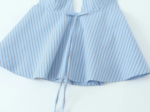 Detail of light blue pinstripe halter top featuring adjustable bow tie and woven texture