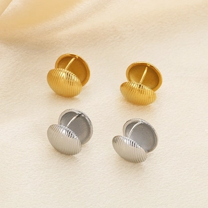 Detailed close-up of gold and silver textured shell-shaped titanium steel earrings