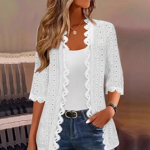 Detail of white lace cardigan showing intricate eyelet embroidery and hollow-out patterns