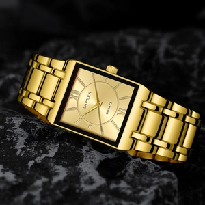 Macro side view of golden rectangular quartz watch with polished stainless steel chain