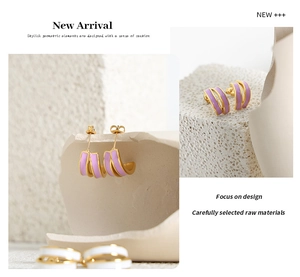 Macro detail of geometric lilac enamel gold earrings on minimalist stone background