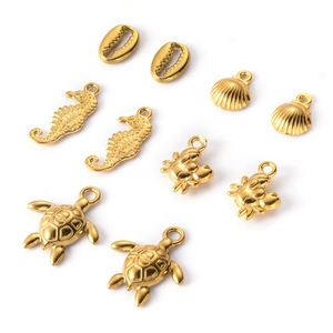 Set of 8 golden stainless steel ocean charms featuring shells, seahorses, crabs and turtles