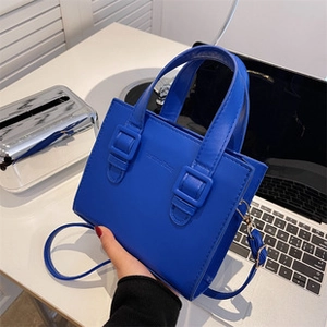 Detail showing the klein blue faux leather tote with classic fashion embossed lettering