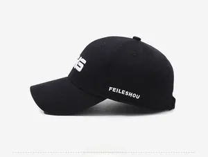 Side view of black cotton baseball cap showing white letter embroidery and fine texture
