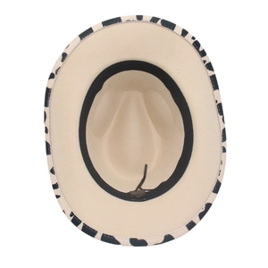 Western cowboy hat featuring a beige felt crown and black and white cow print brim