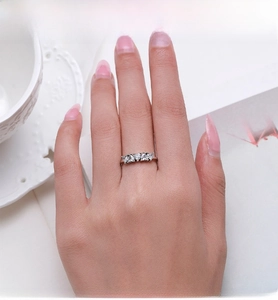 Detail of hand wearing silver ring with five heart-shaped zircons in a row