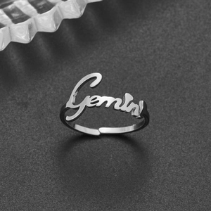 Detailed view of silver stainless steel Gemini zodiac open ring on black texture