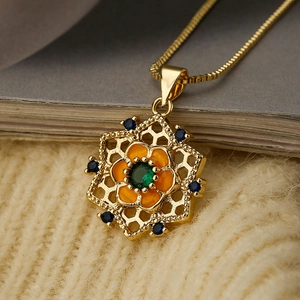 Luxuriöse Goldkette mit orangefarbenem Emaille-Sonnenblumenanhänger und grünem Edelstein-Kern