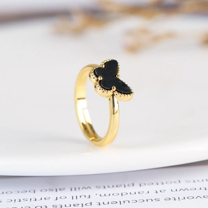 Macro detail of golden butterfly ring with black inlay and beaded edge design