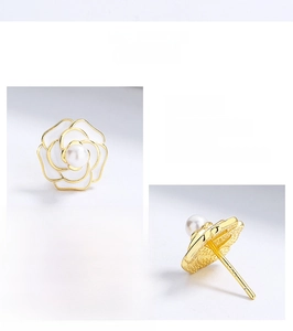 Detailed close-up of 925 sterling silver camellia earrings with white enamel and pearl