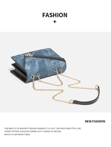 Detail of blue denim shoulder bag with golden chain and black leather strap