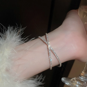 Close-up of elegant silver crossover bracelet with shimmering zircon stones on a wrist