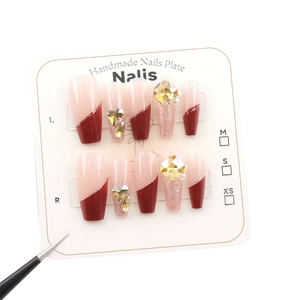 Sparkly cherry red French tip press-on nails with luxury heart crystals and champagne glitter