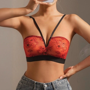 Close-up of orange lace tube top with black floral embroidery and elastic band detail