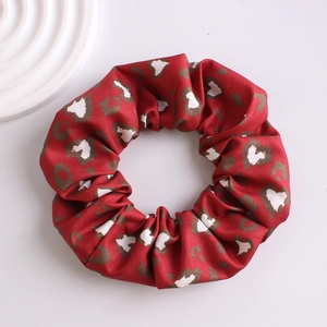 Macro shot of a red leopard print scrunchie with soft fabric texture and elastic design