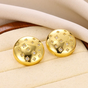 Close-up of star-patterned gold stud earrings with white zircons in a jewelry box