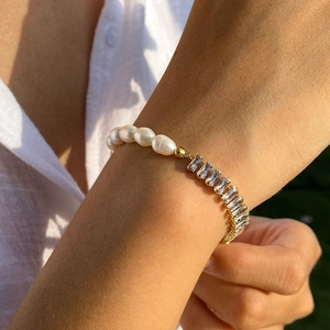 Close-up of pearl and rectangular zircon bracelet with golden plating on model wrist