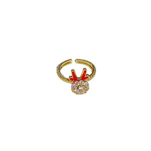 Golden antler open ring with red accents and sparkling center zircon on white background