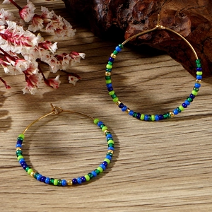 Detailed close-up of Bohemian beaded hoop earrings with colorful beads and gold metal frame