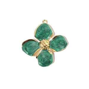 Detail view of green enamel four-leaf clover pendant with gold trim for necklaces