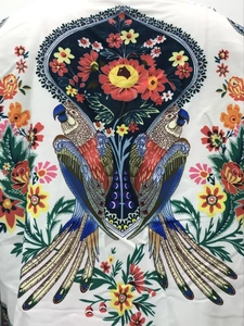 Vue détaillée de l'imprimé perroquet et floral sur une chemise blanche