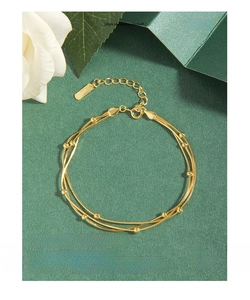 Detailansicht des dreilagigen goldenen Schlangenarmbands mit S925-Punze und Perlen