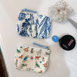 Flat lay of floral and dog print fabric pouches with hair accessories on white surface