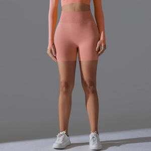 Detail of high-waisted seamless coral pink yoga shorts with ribbed waistband support