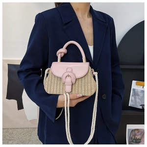 Detail of pink leather flap and straw woven texture on a casual summer handbag