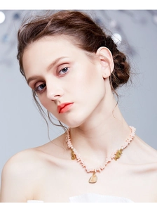 Detail of necklace with pink stones, small pearls, gold seahorses and shell pendant