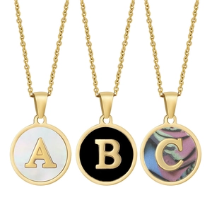 Detailed view of circular gold necklaces with A, B, C letter pendants and shell inlays