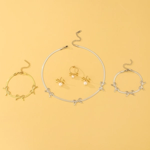 Flat lay of bow-knot jewelry set with pearls including necklace, bracelet and earrings