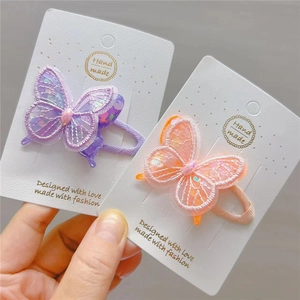 Detail of embroidered butterfly hair clips with sequins and pink synthetic gems for girls