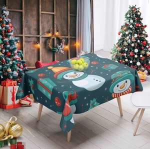 Detail of Christmas tablecloth featuring festive snowmen and gift patterns in cozy setting