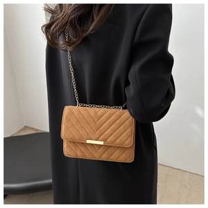 Brown suede crossbody bag featuring a V-shaped chevron quilted pattern and gold chain strap